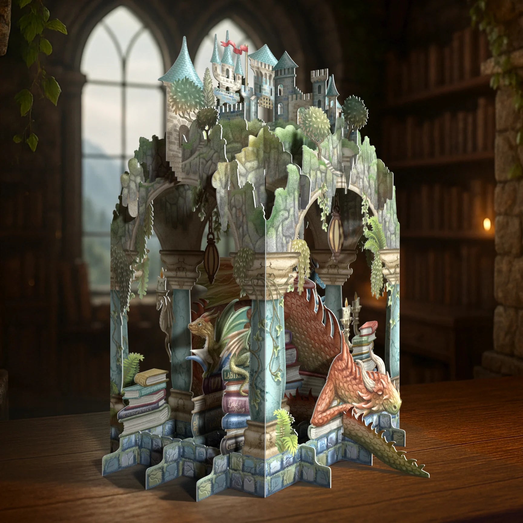 Fantasy castle pop up card with dragons and books on a wooden surface